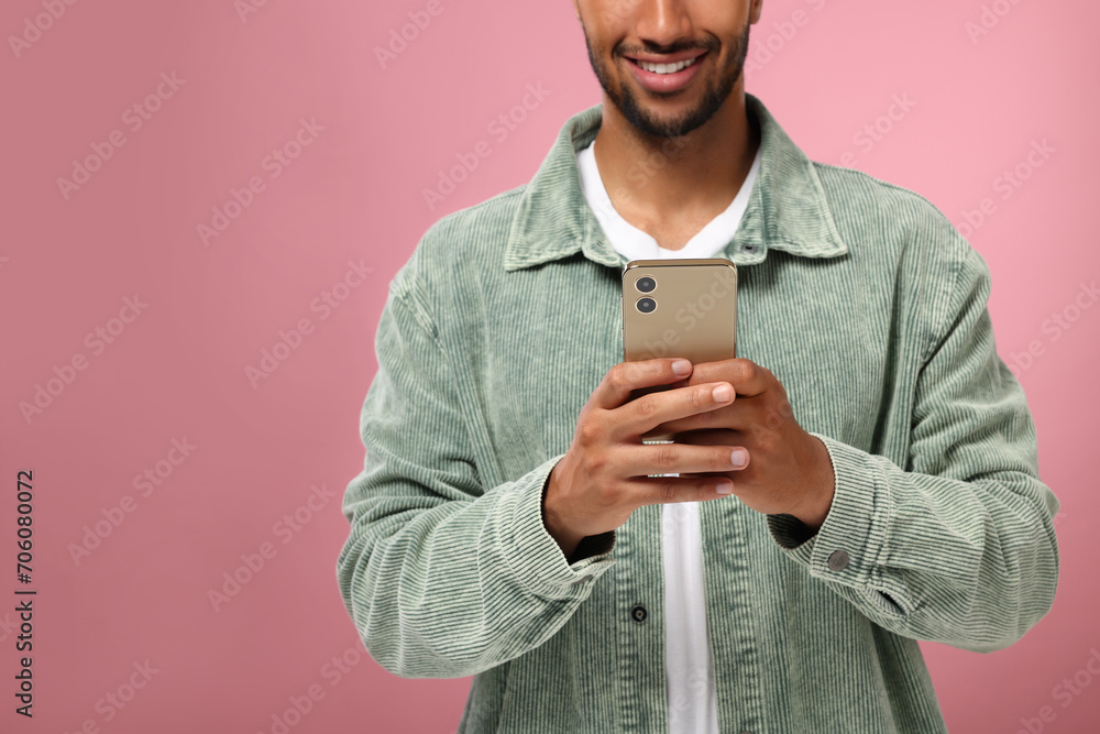 Poster man sending message via smartphone on pink background, closeup. space for text