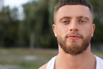Fototapeta premium Portrait of attractive young man outdoors. Space for text