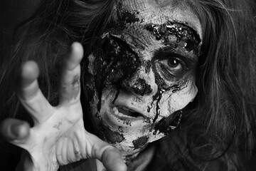 Scary zombie with bloody face, black and white effect. Halloween monster