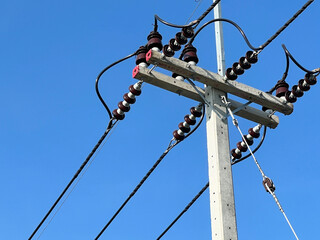 high power lines with high voltage cables on the background of the blue sky.