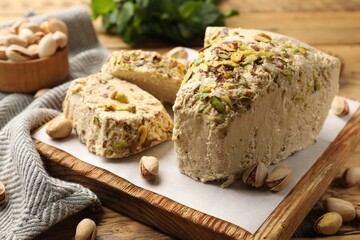 Tasty halva with pistachios on table, closeup