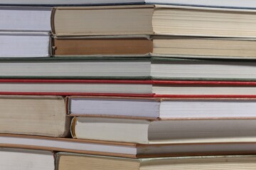 Stack of many different hardcover books as background, closeup
