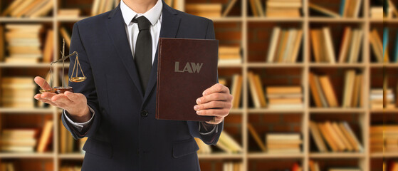 Male lawyer with book and scales of justice in office. Banner for design