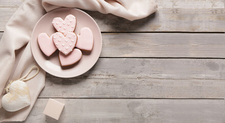 Plate with tasty heart shaped cookies on grey wooden background with space for text. Valentine's Day celebration