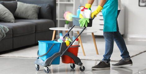 Male janitor with cleaning supplies in flat