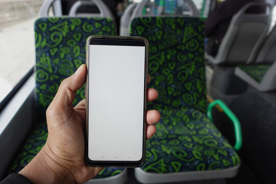 passenger sitting in a bus using his phone.