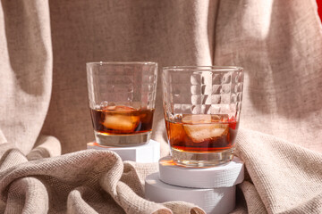 Glasses of rum with ice cubes on tablecloth