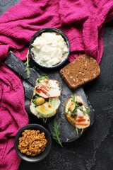 Composition with tasty sandwiches, cream cheese and mustard on dark background