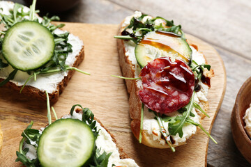 Wooden board of delicious sandwiches, closeup