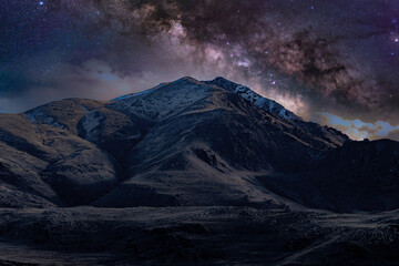 Milky Way galaxy over a snow-capped mountain