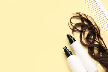 Curled brown hair with sprays and comb on yellow background