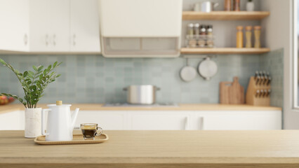 A wooden tabletop with a coffee pot, a coffee cup, and a copy space in a modern kitchen.