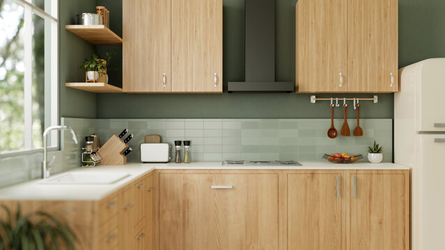 Interior design of a modern green kitchen with kitchen appliances, wooden cabinets, and green wall.