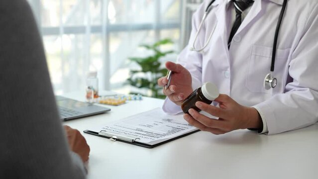 Asian male doctor or medical specialist examining a patient Ask for symptoms, give advice, recommend medication, plan treatment guidelines and preventive care. Concept of health checkup Prevention.