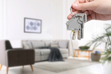 Woman holding house keys in room, closeup