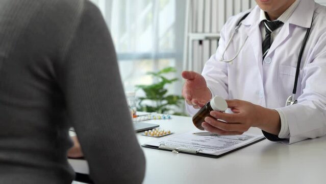 Asian male doctor or medical specialist examining a patient Ask for symptoms, give advice, recommend medication, plan treatment guidelines and preventive care. Concept of health checkup Prevention.