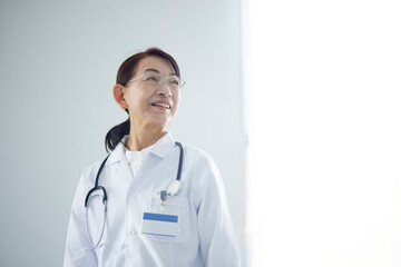 白衣を着た日本人のシニア女性医師 - obrazy, fototapety, plakaty