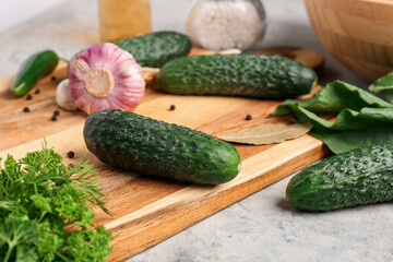 Wooden board with fresh cucumbers for preservation on table