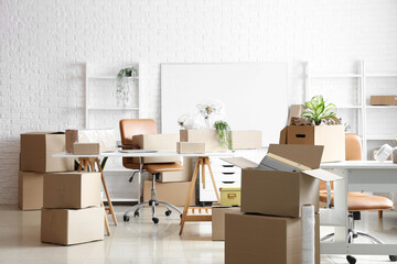 Workplaces with cardboard boxes in office on moving day