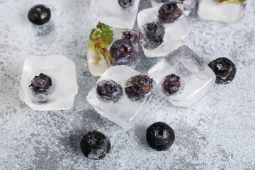 Fresh blueberry frozen in ice cubes on grunge background