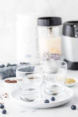 Ingredients and blender ready for blending a protein blueberry smoothie.