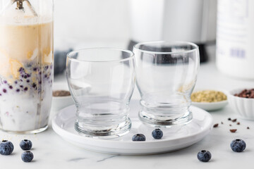 A blender cup full of ingredients to make a healthy blueberry smoothie.