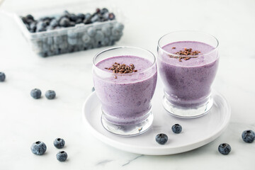 Glasses of fresh homemade blueberry smoothie with cacao nibs.