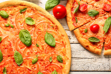 Tasty pizzas margarita on white wooden background
