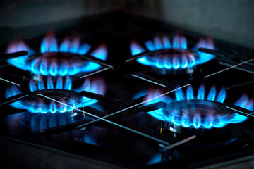 Burning blue flames gas. Focus on the front edge of the gas burners. Gas burners on a home stove. Gas crisis.