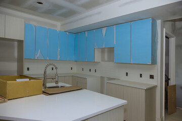 Building new house with custom modular kitchen that consists of cabinets an island in center