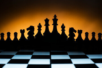 Ajedrez. Wallpaper de contraluces de piezas de ajedrez con una luz amplia por detras calida...