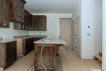 Under construction is new home with custom modular kitchen consisting of cabinets an island in...