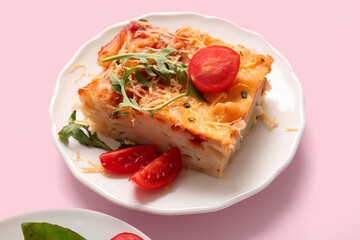 Plate of pasta with tomato sauce and cheese on pink background
