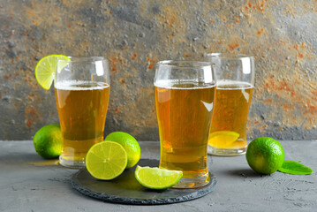 Glasses of cold beer with lime on table