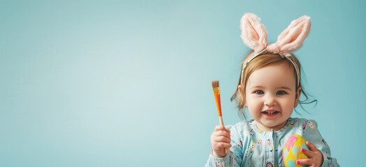 Happy smile baby little girl hold painted Easter eggs, blue background