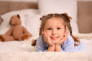 Cute little girl lying in bedroom, closeup