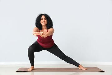 Fototapeta premium Sporty adult woman practicing yoga on grey background