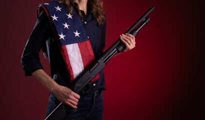 Armed citizen holding a shotgun with an American flag over her shoulder