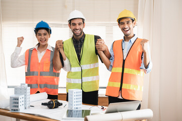 Multi ethnicity group of engineers, architects and construction worker or business people holding colleagues hand showing successful teamwork or unity, Architecture and Engineering business concept.