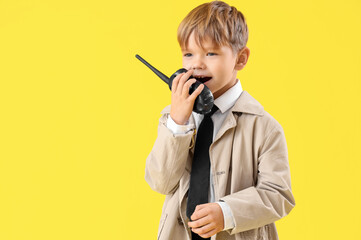 Cute little detective with radio transmitter on yellow background. Opposite Day celebration