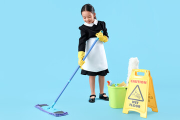 Cute little chambermaid mopping on blue background. Opposite Day celebration