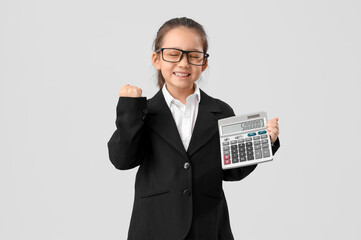Cute little businesswoman with calculator on light background. Opposite Day celebration