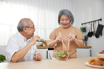 senior couple enjoy cooking and eating salad in the kitchen