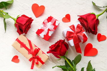 Beautiful roses with paper hearts and gift boxes on white background. Valentine's Day celebration