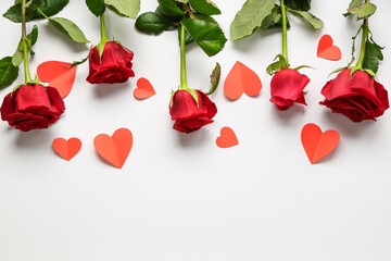 Beautiful roses with paper hearts on white background. Valentine's Day celebration
