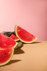 Front view of juicy watermelon slices decorated on a pink background with gray stone. Watermelon is like the ultimate summer go-to for when you’re really parched and need to rehydrate your system