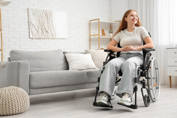 Smiling young redhead woman in wheelchair at home