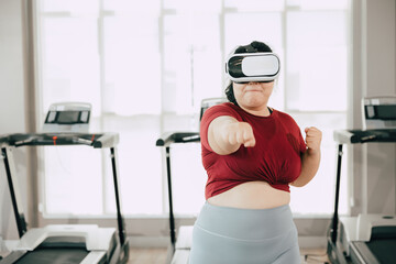 fat women with VR headset play visual reality sport game for exercise. people using modern...