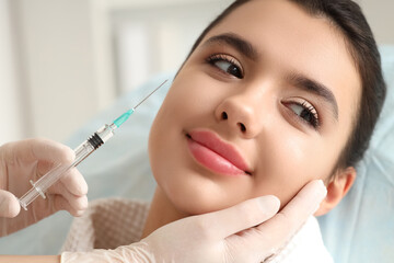 Young woman receiving injection in beauty salon, closeup