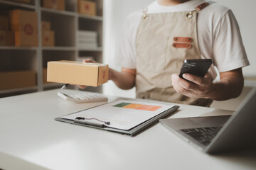 Smartphones are being used to do various activities to promote sales to stores, owner of an online store packs products into parcel boxes based on orders from online sales sites.